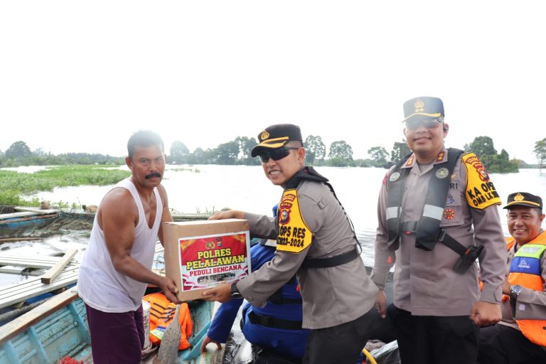 Naik Perahu Karet, Kapolres Pelalawan ajak Bhayangkari Door to door Sambagi warga dan memberikan Bansos kepada masyarakat yang terisolir oleh Banjir
